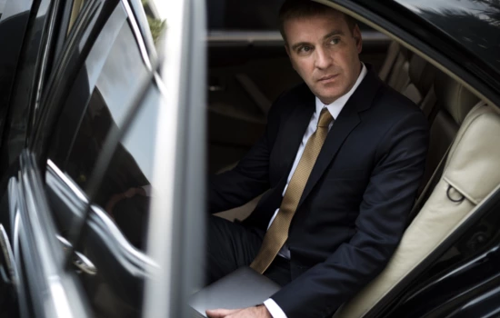 A man sitting in a luxury black town car